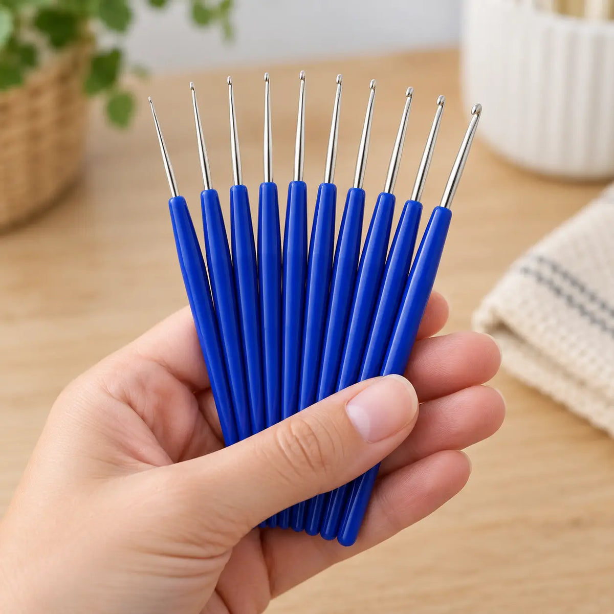 Complete 10-piece fine steel crochet hook set shown at hand scale
