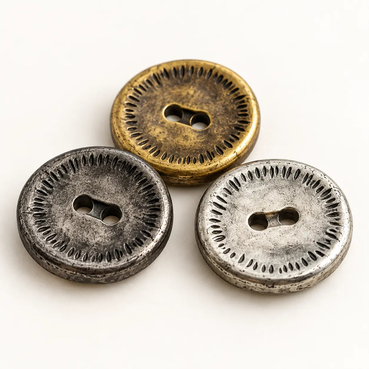 Macro detail of vintage 18 mm metal buttons showing the two-hole centers and engraved rims