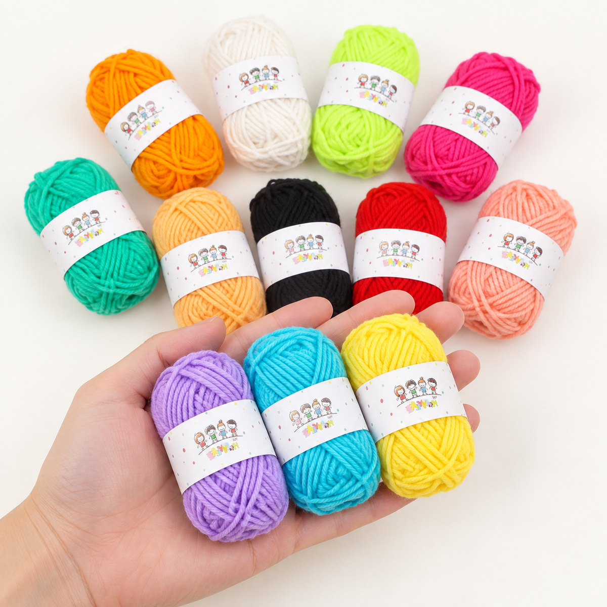 Three mini acrylic yarn skeins held in one hand with the remaining colours behind