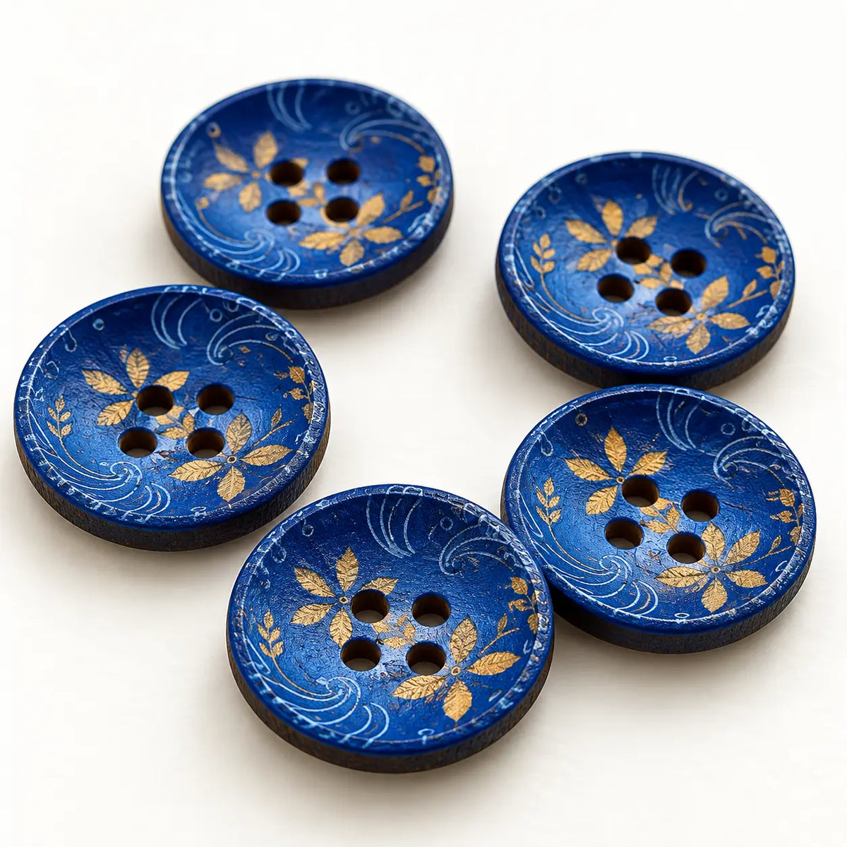 Macro view of blue-and-gold 15 mm wooden buttons showing four holes and thin wood edges