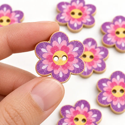 A 20 mm purple flower-shaped two-hole wooden button held between fingertips