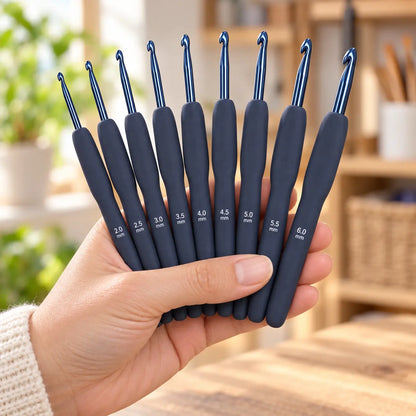 Complete 9-piece dark-blue soft-grip crochet hook set shown at hand scale