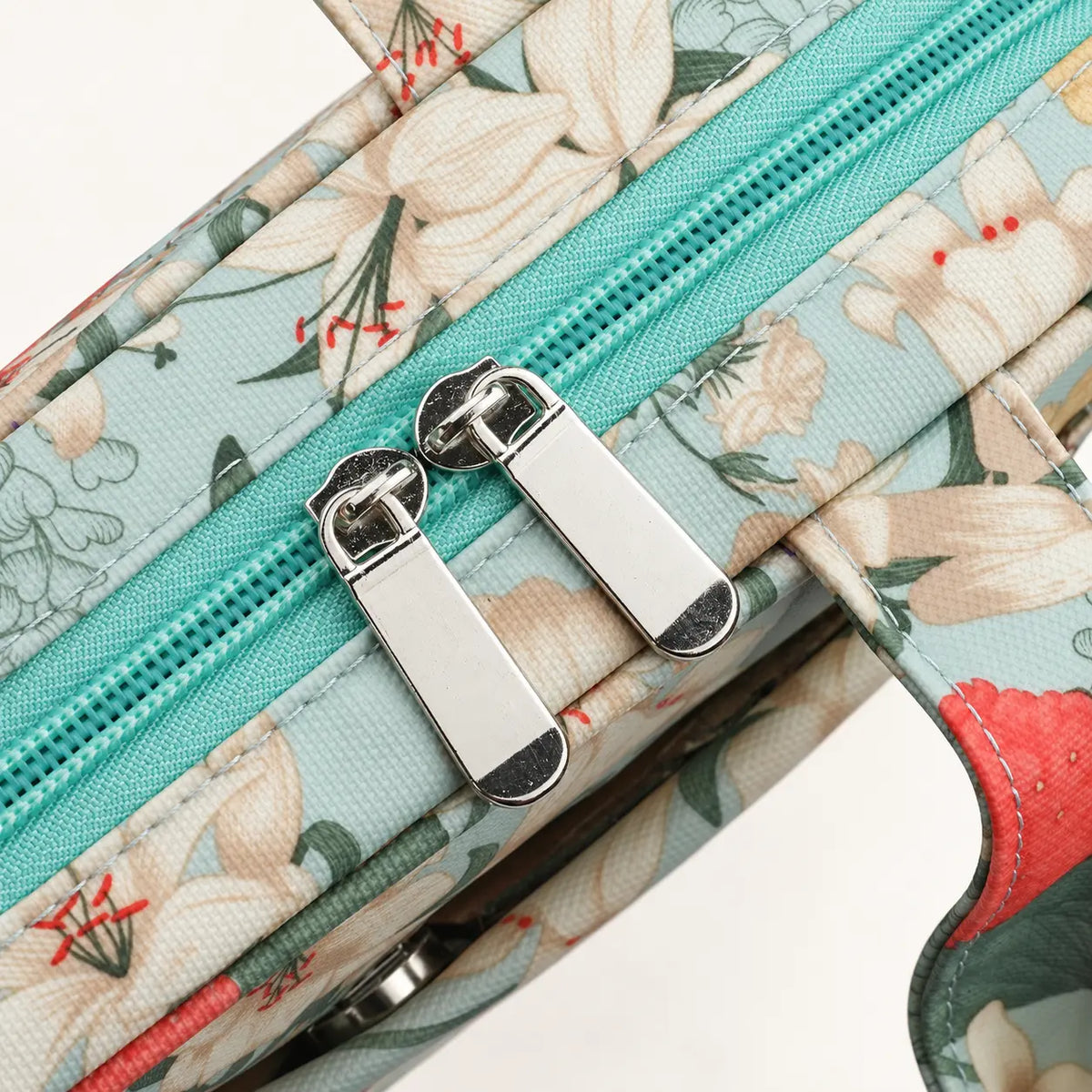 Close-up of the aqua zipper and silver double pulls on the floral crochet hook organizer case