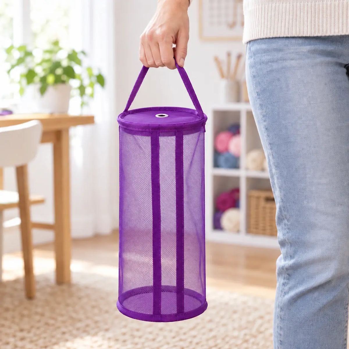 Large purple mesh yarn storage bag carried by its handle for scale