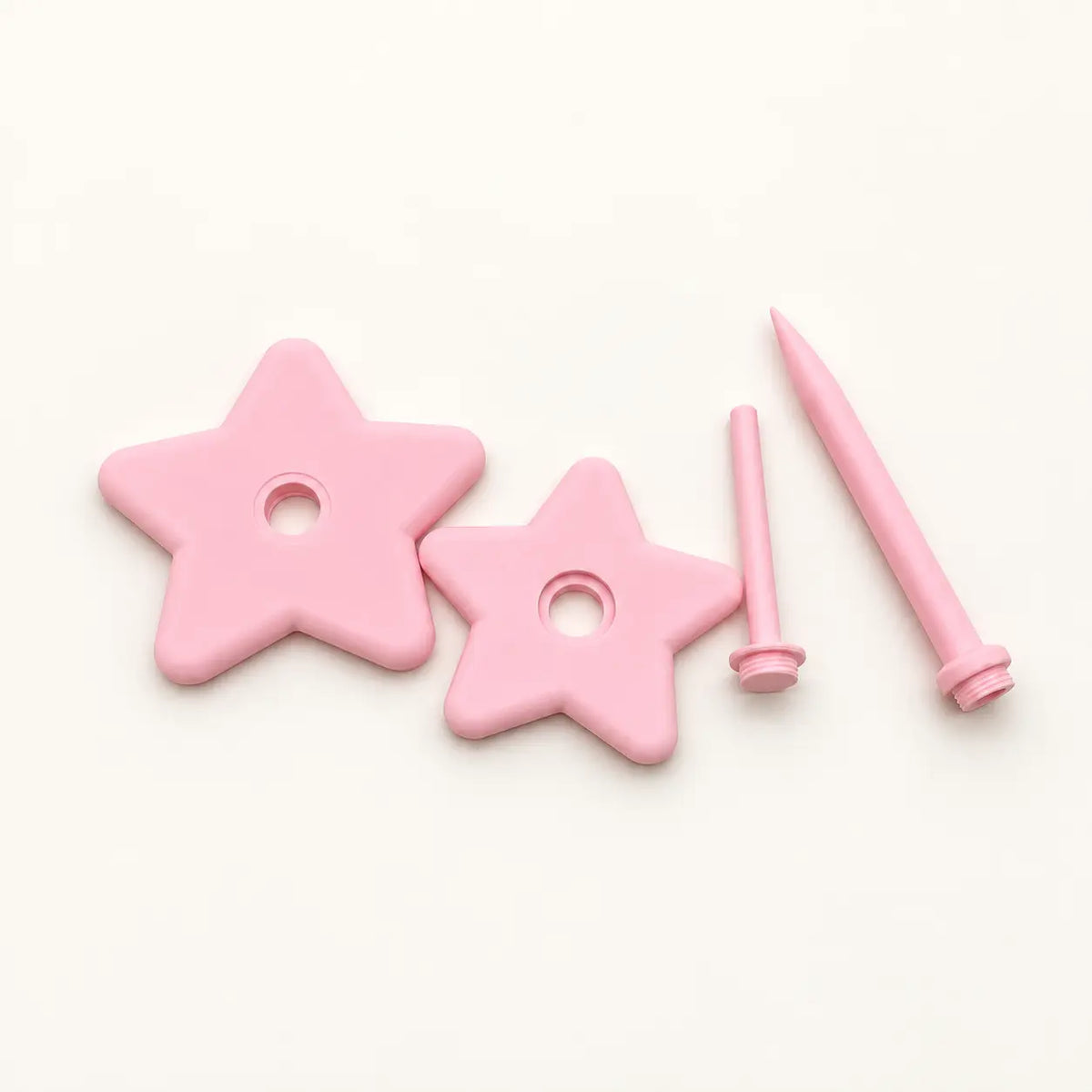 Pink rotating star yarn holder components laid out before assembly
