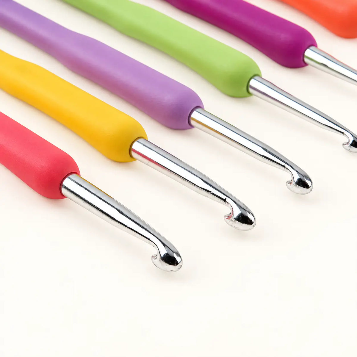 Close-up of chrome crochet hook tips and colourful soft grips