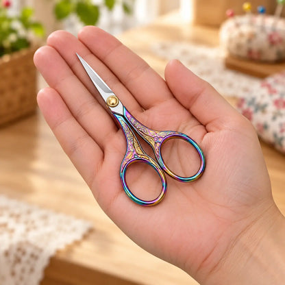 Iridescent vintage-style embroidery scissors shown at hand scale